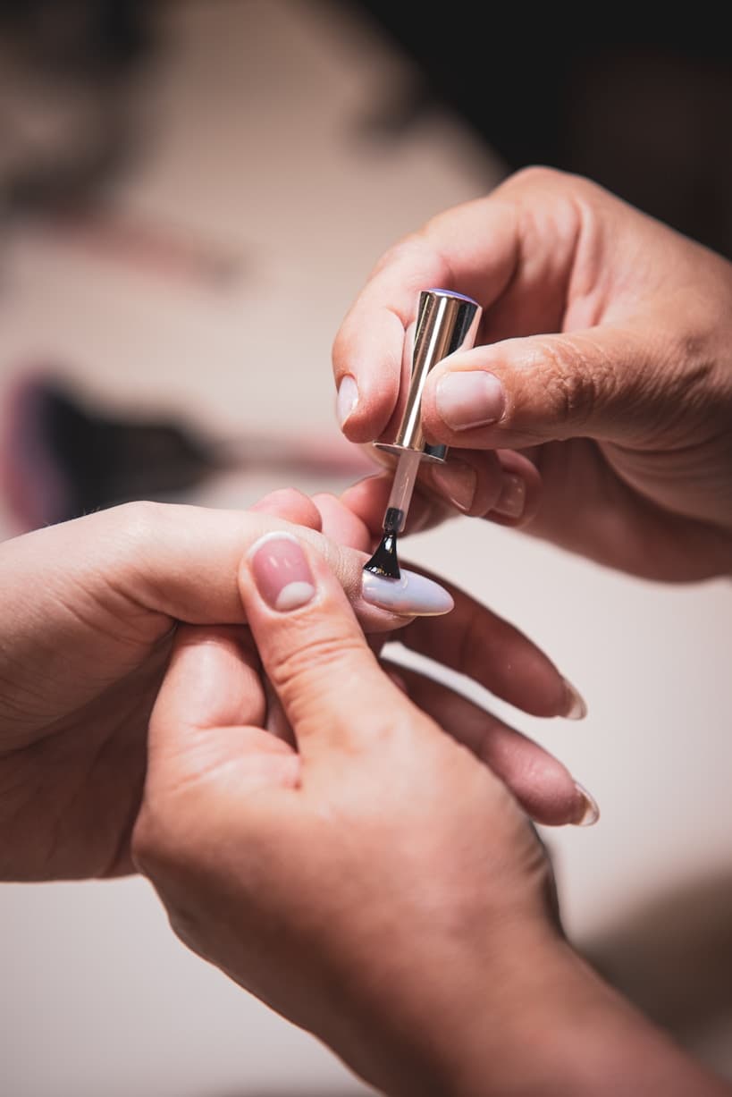 Nagellack wird auf einen Fingernagel aufgetragen